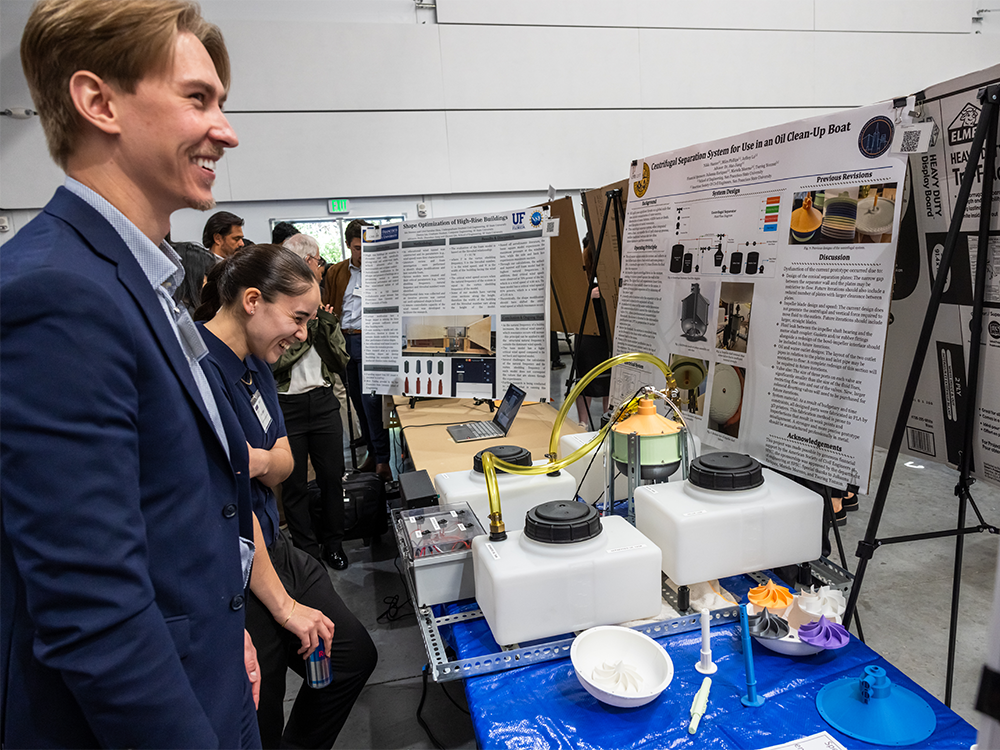 Students laughing next to their project at CoSE showcase