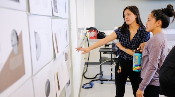 students looking at work on a classroom wall